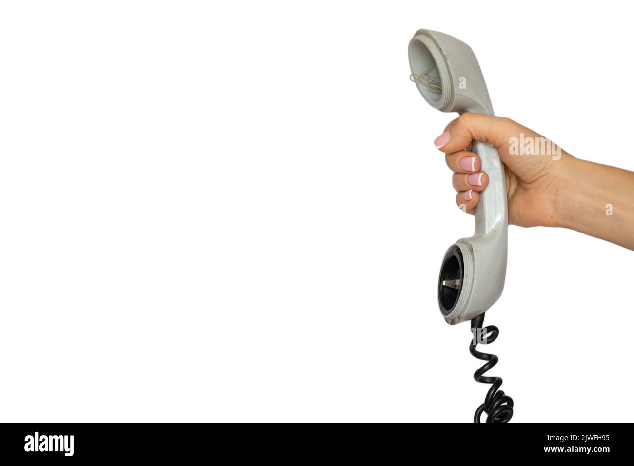 Un vecchio ricevitore telefonico rotto da un telefono fisso in mano a una ragazza su uno sfondo bianco, un telefono rotto, una chiamata Foto Stock