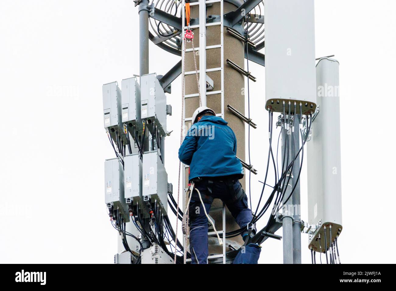 due tecnici eseguono riparazioni su un montante radio Foto Stock