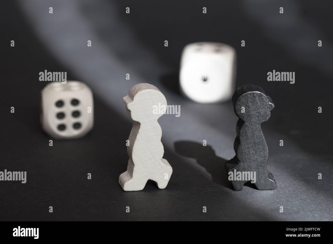 Concetto opposto. Due figure di gioco si sono voltate l'una verso l'altra. Bianco e nero. Diverse razze di persone. Uguaglianza per tutti gli esseri umani. Foto Stock