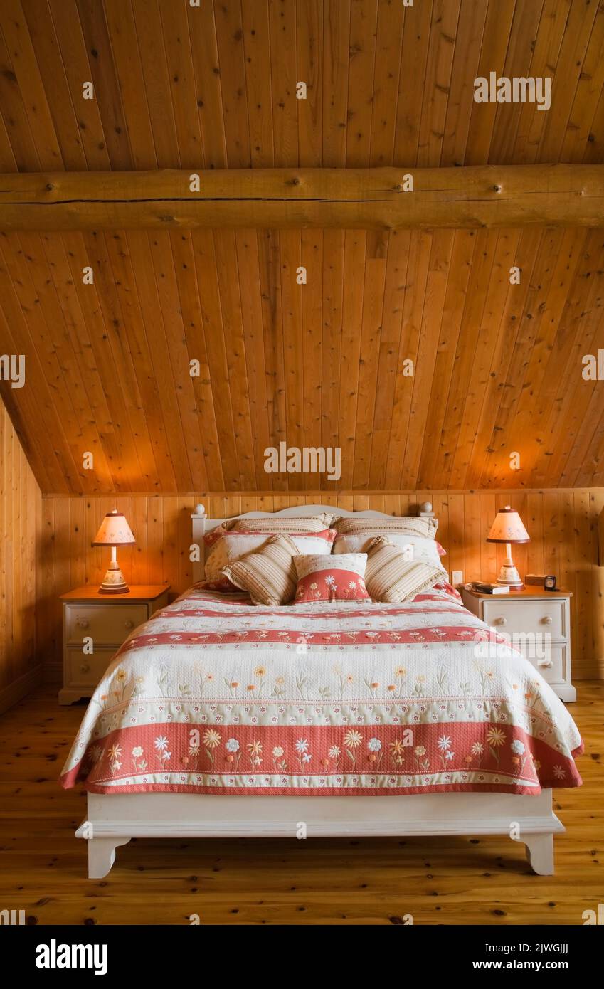 Letto king size nella camera da letto principale al piano superiore, all'interno di una casa in legno di abete rosso artigianale. Foto Stock