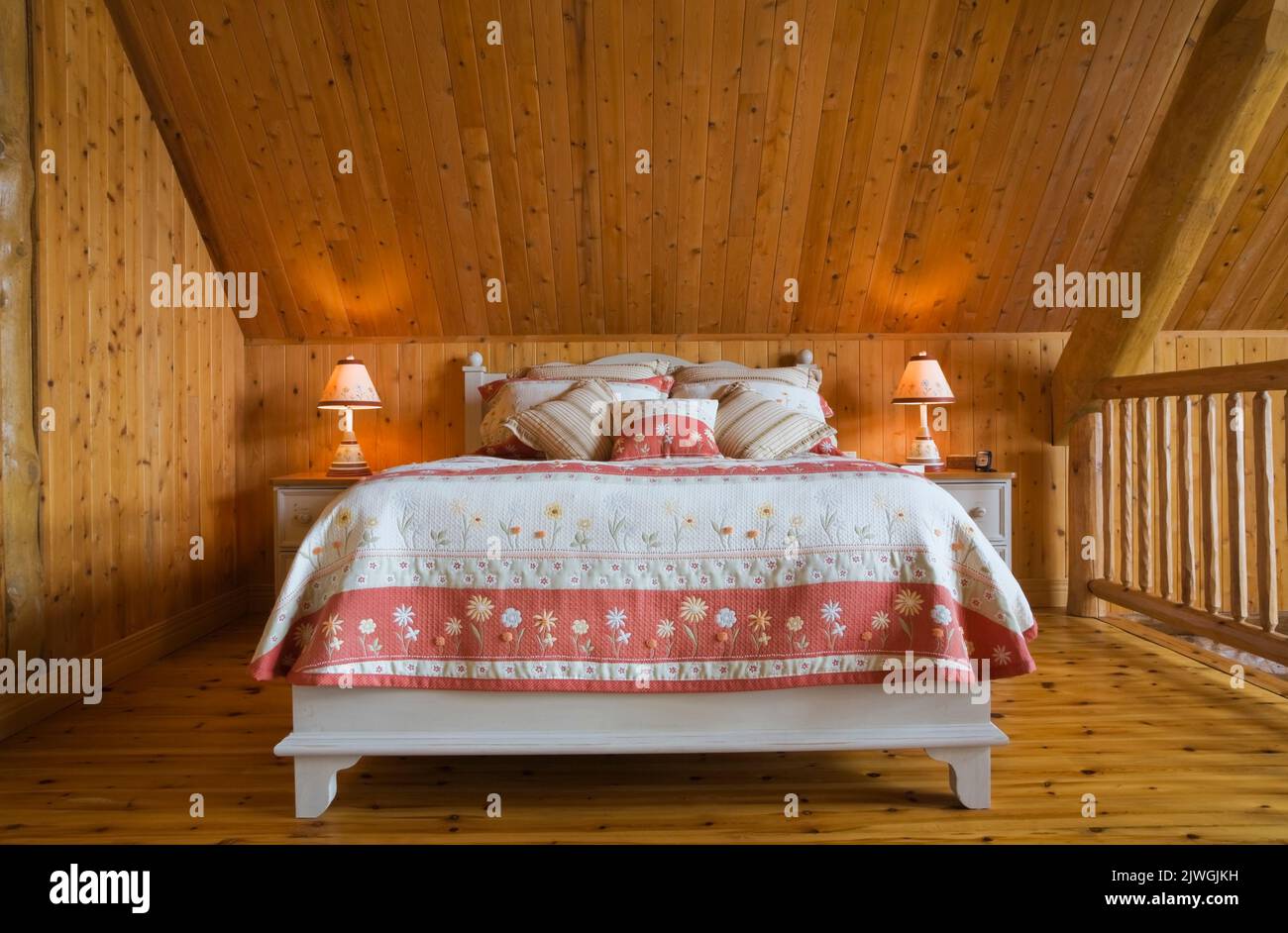 Letto king size nella camera da letto principale al piano superiore, all'interno di una casa in legno di abete rosso artigianale. Foto Stock