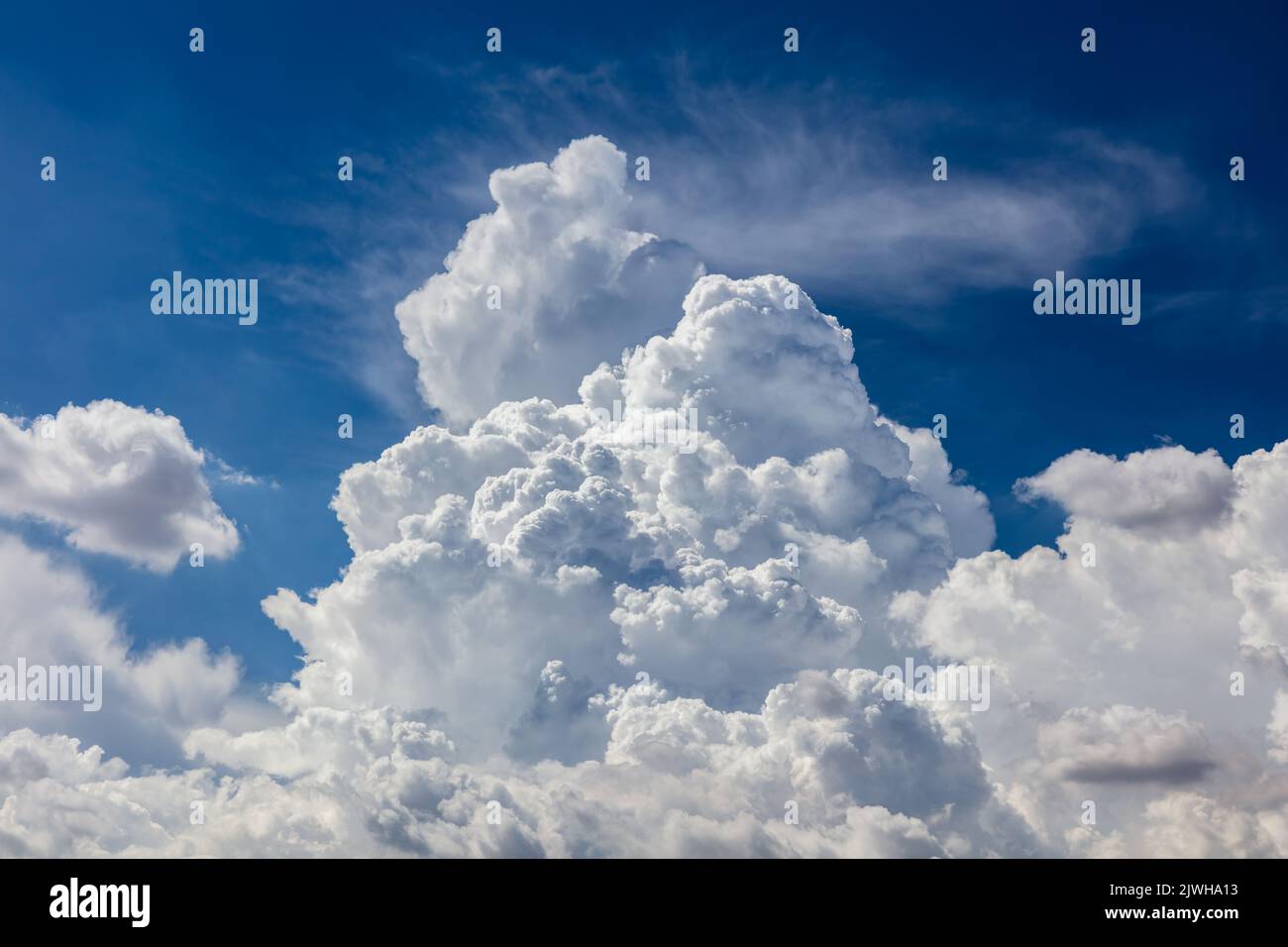 Primo piano di nuvole di cumuli bilici. Nuvole spionate, cielo blu profondo sullo sfondo. Foto Stock