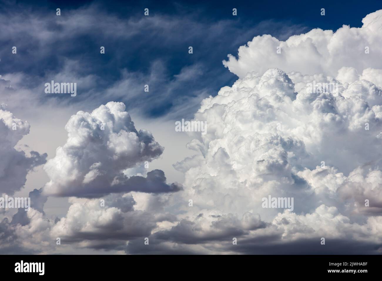 Primo piano di nuvole di cumuli bilici. Nuvole spionate, cielo blu profondo sullo sfondo. Foto Stock