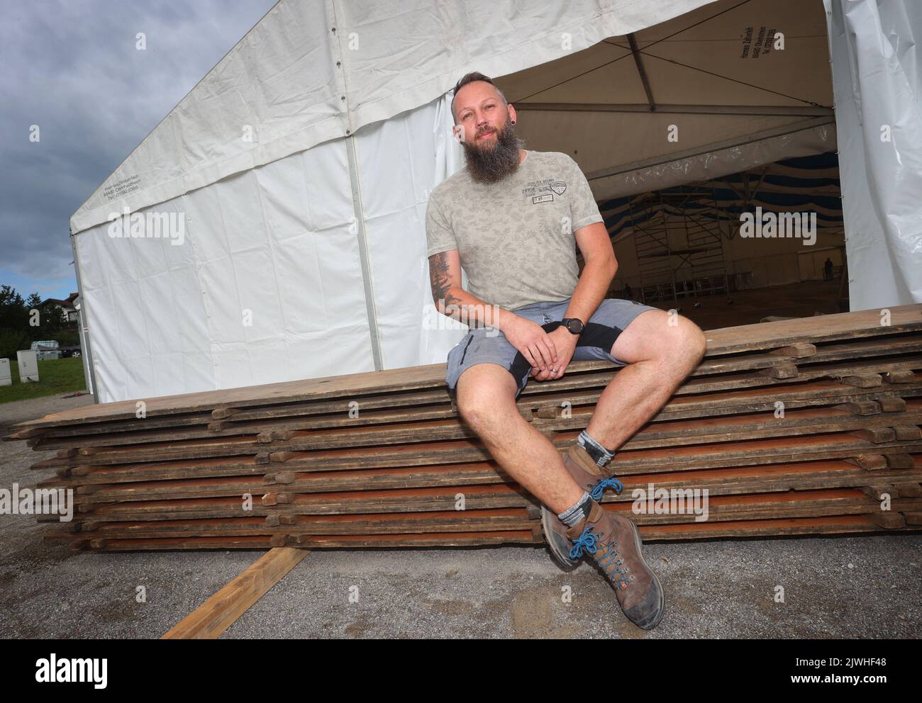 03 settembre 2022, Baviera, Maierhöfen: Thomas Holzer, capo dell'associazione Viehscheid, siede sulle panchine della birra di fronte ad un tendone attualmente in costruzione. Per la prima volta in mezzo secolo, non ci sarà Altrabtrieb a Maierhöfen. Invece, la fine dell'estate alpina sarà celebrata con una festa locale. Foto: Karl-Josef Hildenbrand/dpa Foto Stock