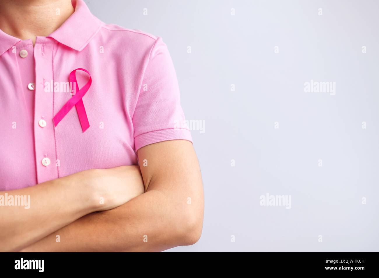 Mese rosa ottobre di consapevolezza del cancro al seno, la mano della donna tiene il nastro rosa e indossa la camicia per sostenere la vita e la malattia della gente. Sopravvissuti nazionali al cancro Foto Stock