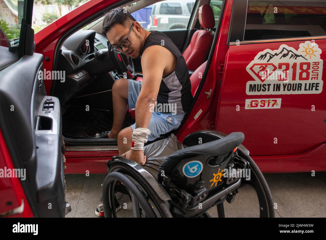 (220906) -- CHENGDU, 6 settembre 2022 (Xinhua) -- egli Peng si sposta dalla sua auto alla sedia a rotelle presso il suo campo di addestramento di riabilitazione a Chengdu, provincia sudoccidentale del Sichuan, il 27 agosto 2022. Nato a Mianyang, nella provincia del Sichuan, nel sud-ovest della Cina, He Peng, 38 anni, ha subito una lesione del midollo spinale in un incidente automobilistico nel 2005, lasciandolo paraplegico dal collo verso il basso. Nel corso degli anni, è riuscito a realizzare una serie di corsi di riabilitazione. La prima sfida per i pazienti con lesioni del midollo spinale è quella di recuperare la loro capacità di prendersi cura di se stessi, ha detto Peng. Ci sono voluti 5 anni dalla sdraiarsi Foto Stock