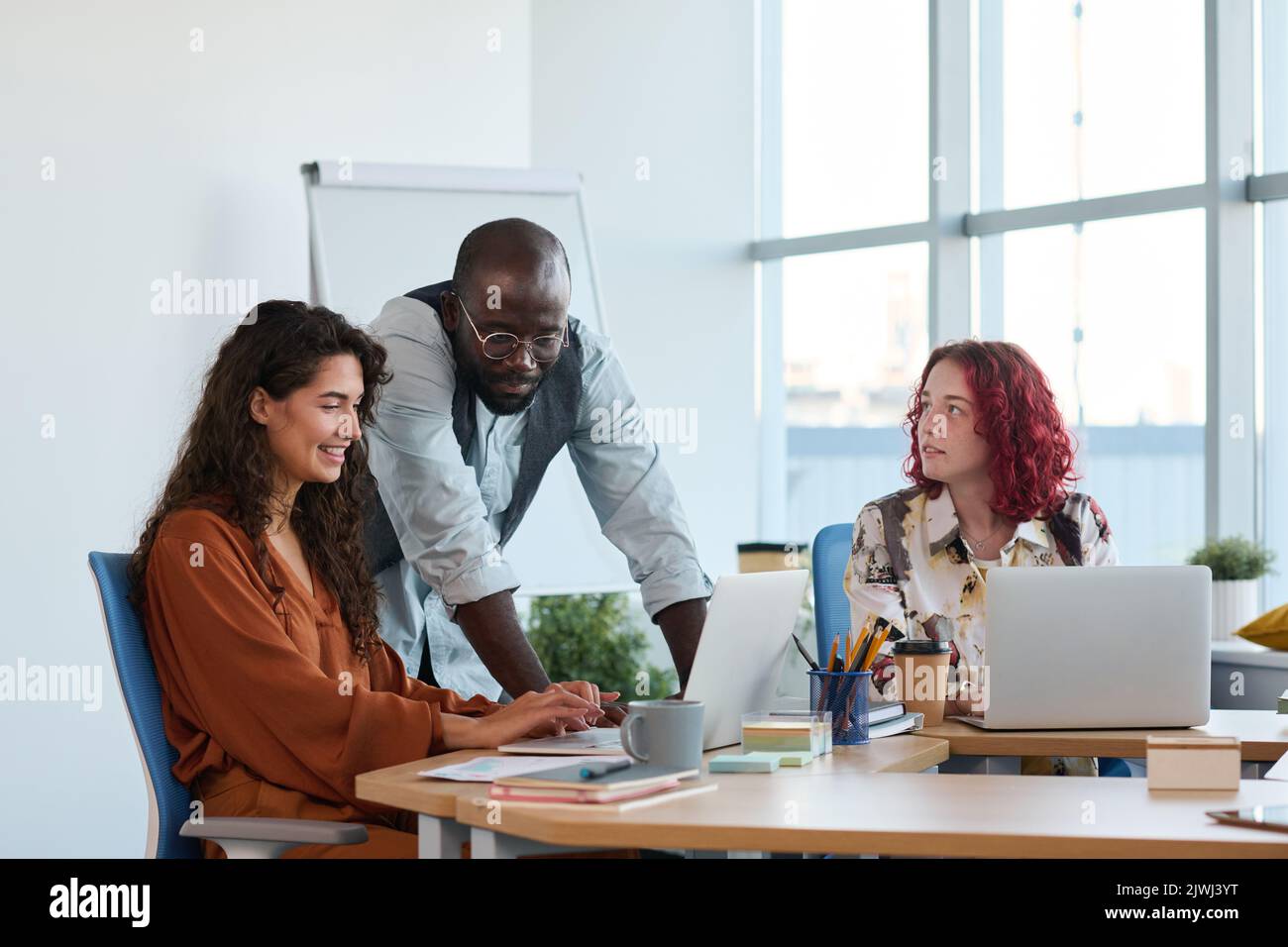 Gruppo di giovani manager interculturali di successo che preparano la presentazione del nuovo progetto di business prima della conferenza alla riunione in carica Foto Stock