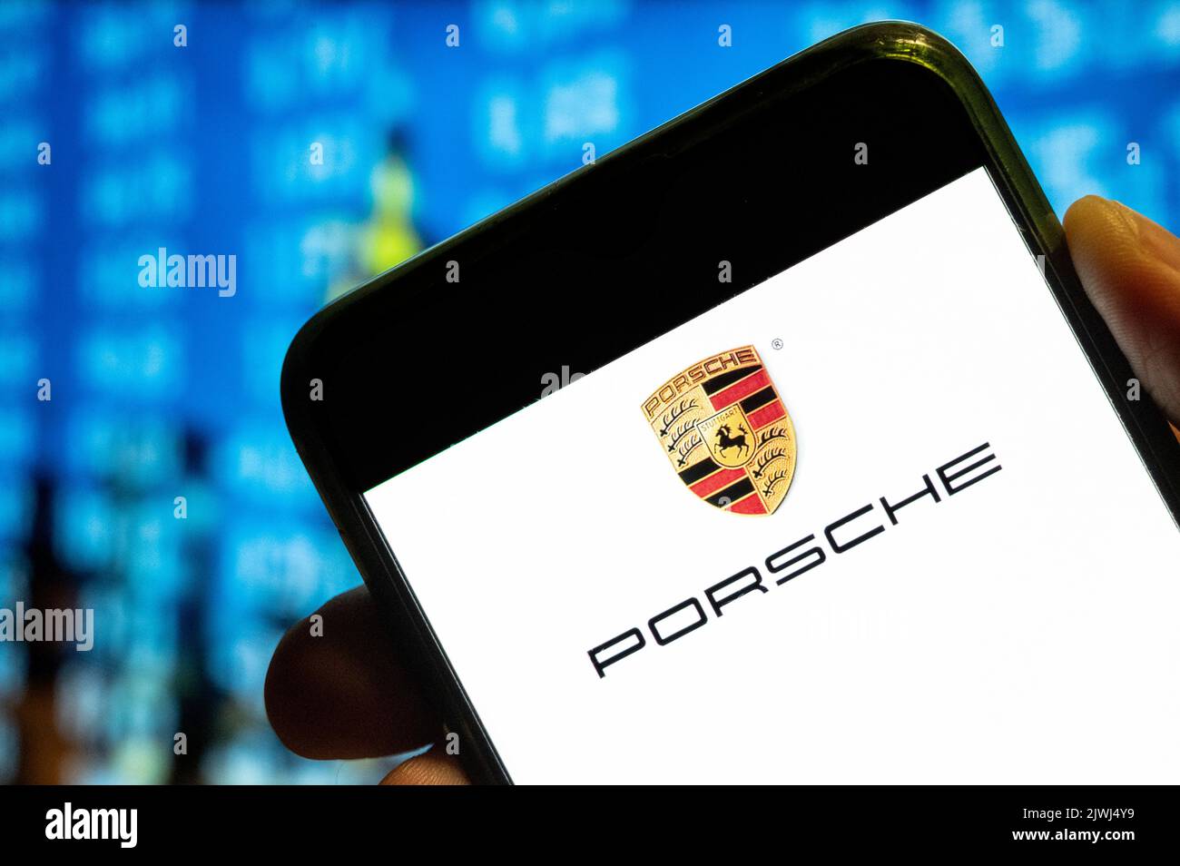 In questa foto, sullo schermo dello smartphone viene visualizzato il logo Porsche dell'azienda tedesca di lusso specializzata in veicoli sportivi. Foto Stock