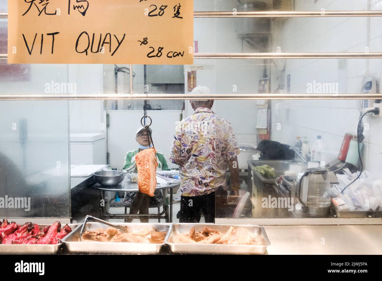 Due uomini all'interno di un negozio vietnamita di carne barbecue a Cabramatta - Sydney, Australia Foto Stock