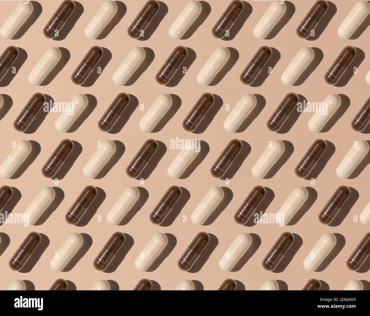 Capsule sulla vista dall'alto beige chiaro, ombre dure, motivo creativo. Medicina preventiva e sanità, prendendo integratori alimentari e vitamine. Ass Foto Stock