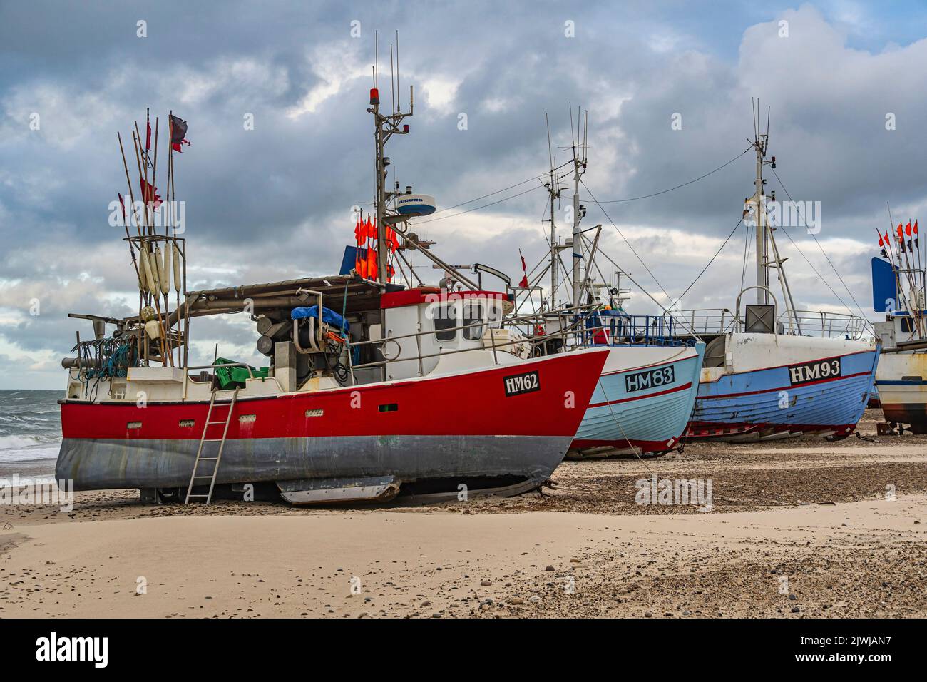 Barche da pesca tirato a riva in attesa della tempesta. Nel piccolo villaggio di pescatori di Thorupstrand, la pesca sostenibile è praticata. Jammerbugt, Danimarca Foto Stock