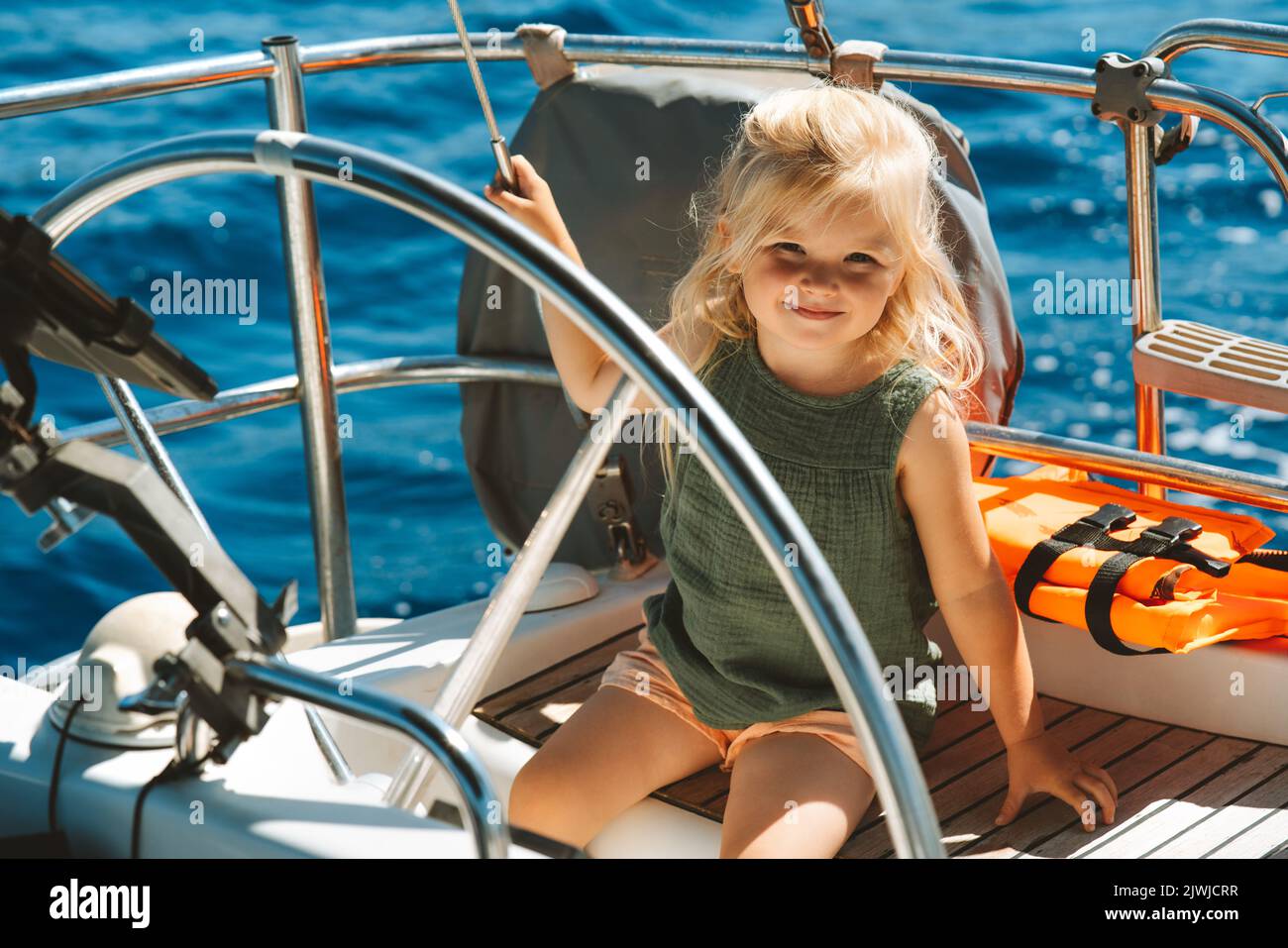 Ragazza bambino che viaggia su yacht famiglia vacanze attive crociera mare blu vista vacanze estive Foto Stock