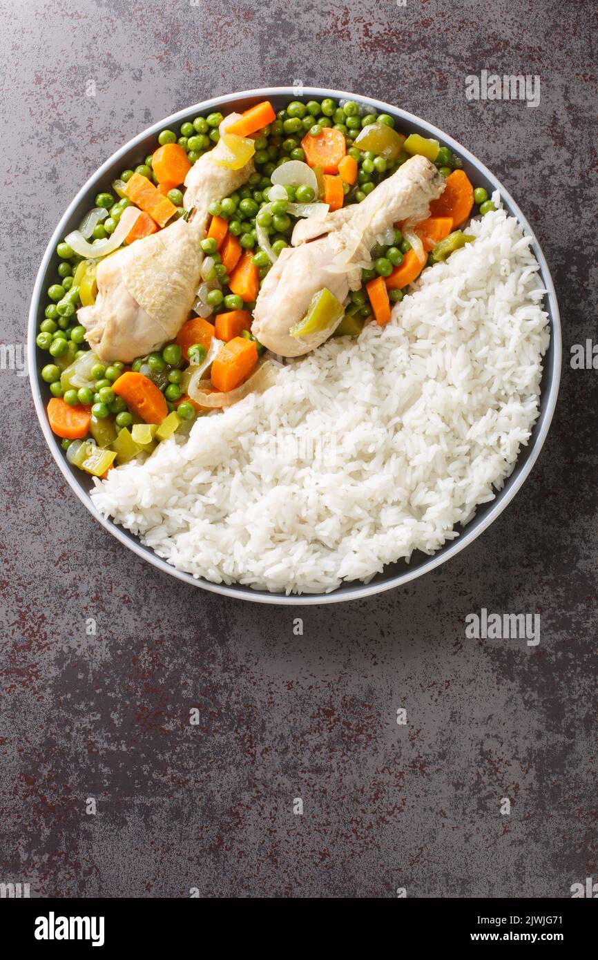 Pollo Arvejado o piselli e carote Stew di pollo è un classico cileno comfort piatto closeup nel piatto sul tavolo. Vista verticale dall'alto Foto Stock