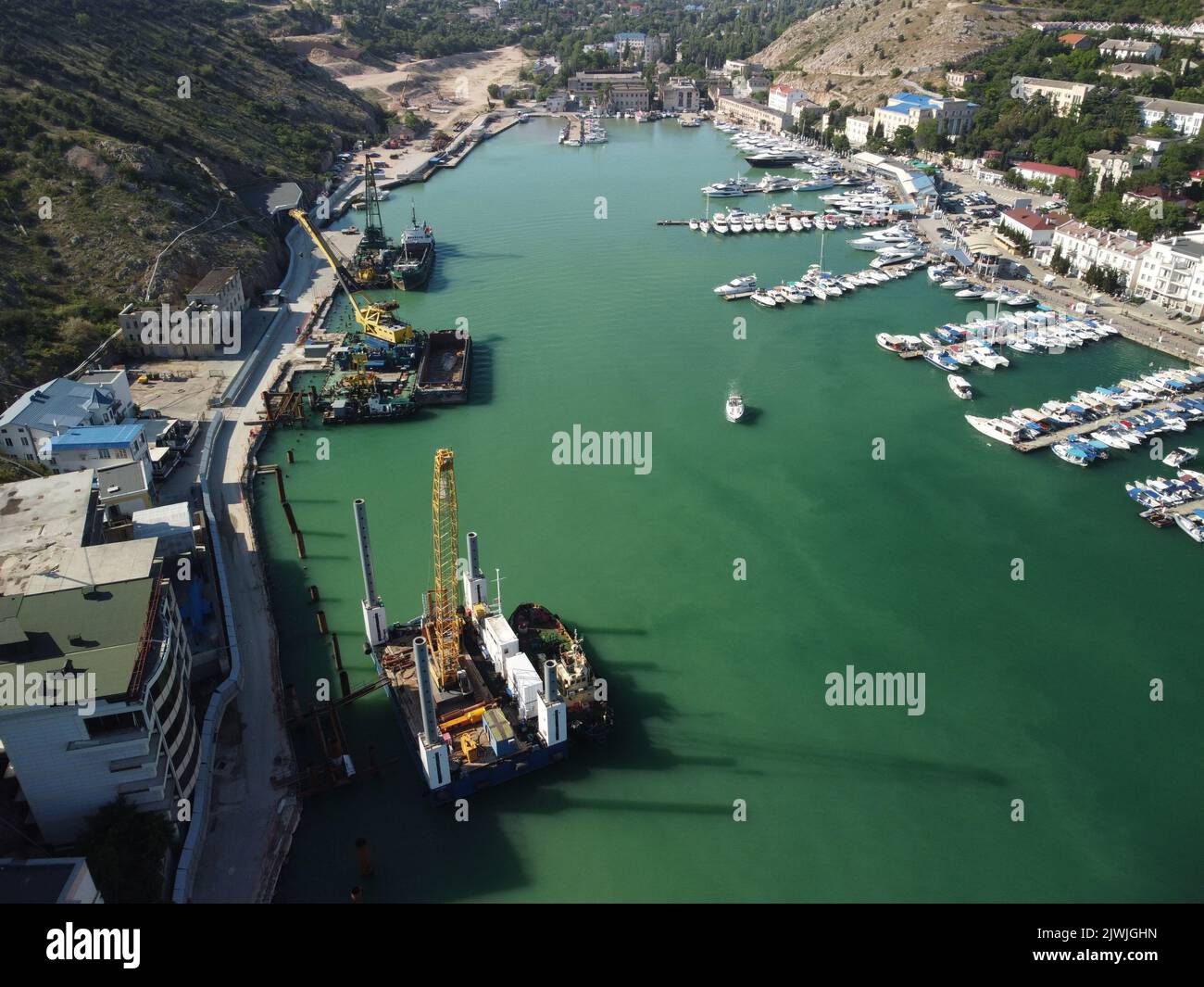 Carroponte galleggiante che dragano chiatte che lavorano per la costruzione di un porto turistico. Vista dall'alto dell'antenna Foto Stock