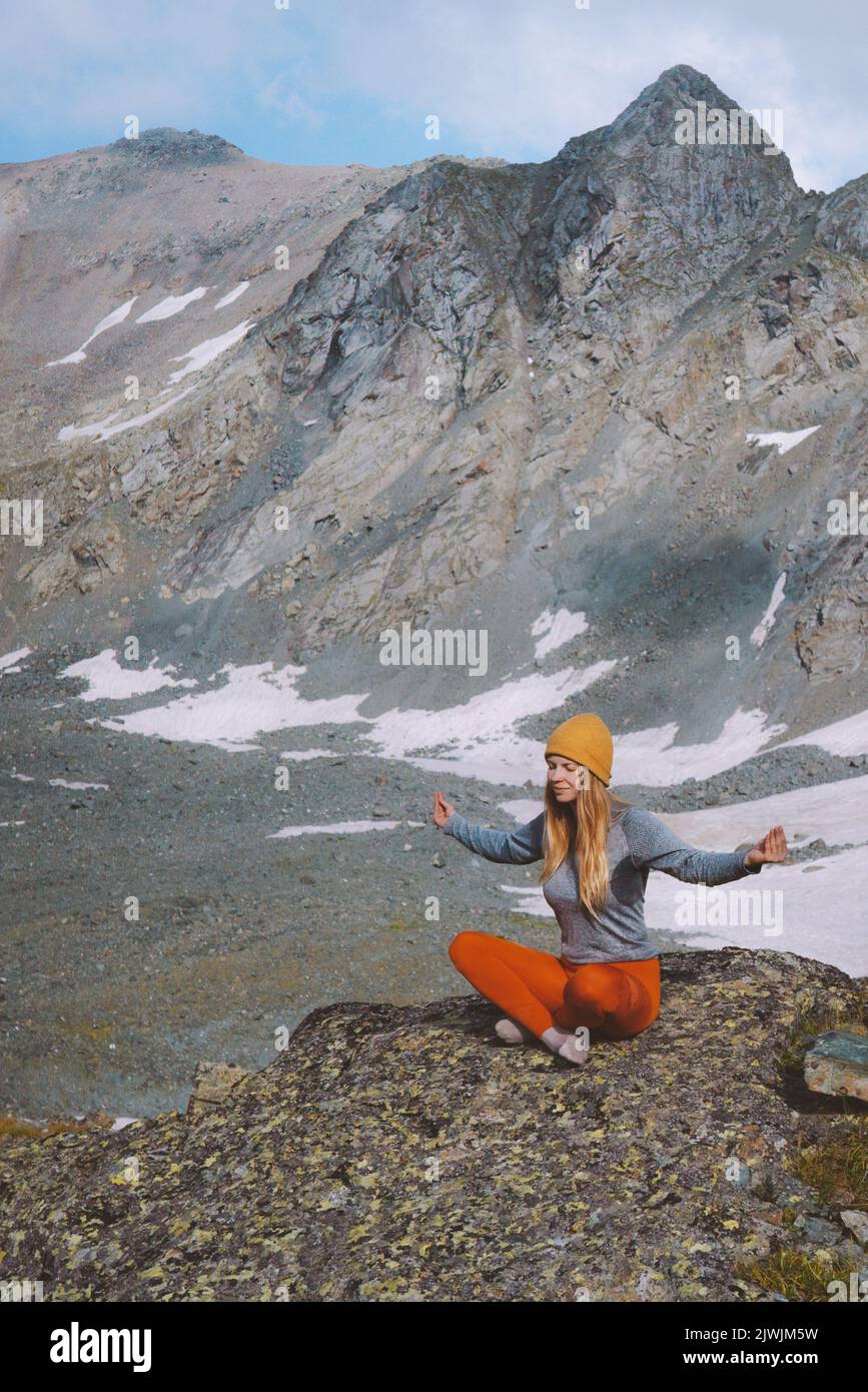 Meditazione in montagna donna pratica yoga all'aperto Viaggi trekking sano stile di vita salute mentale mente relax vacanze viaggio armonia con la natura Foto Stock