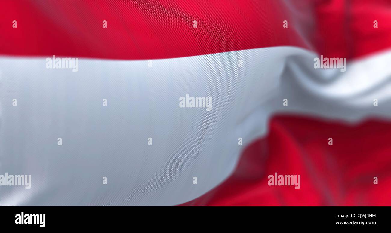 Vista ravvicinata della bandiera nazionale austriaca che sventola nel vento. L'Austria è un paese senza sbocco sul mare nella parte meridionale dell'Europa centrale. Tessitura del tessuto Foto Stock