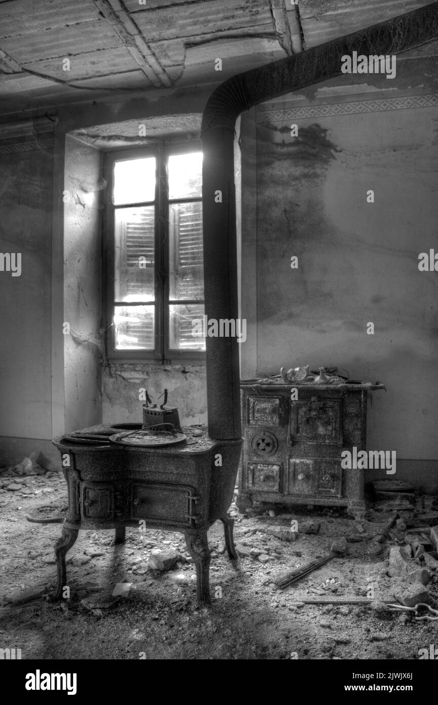 Settembre 2022, Italia. UrbEx vecchia stufa in ghisa arrugginita in una casa abbandonata Foto Stock