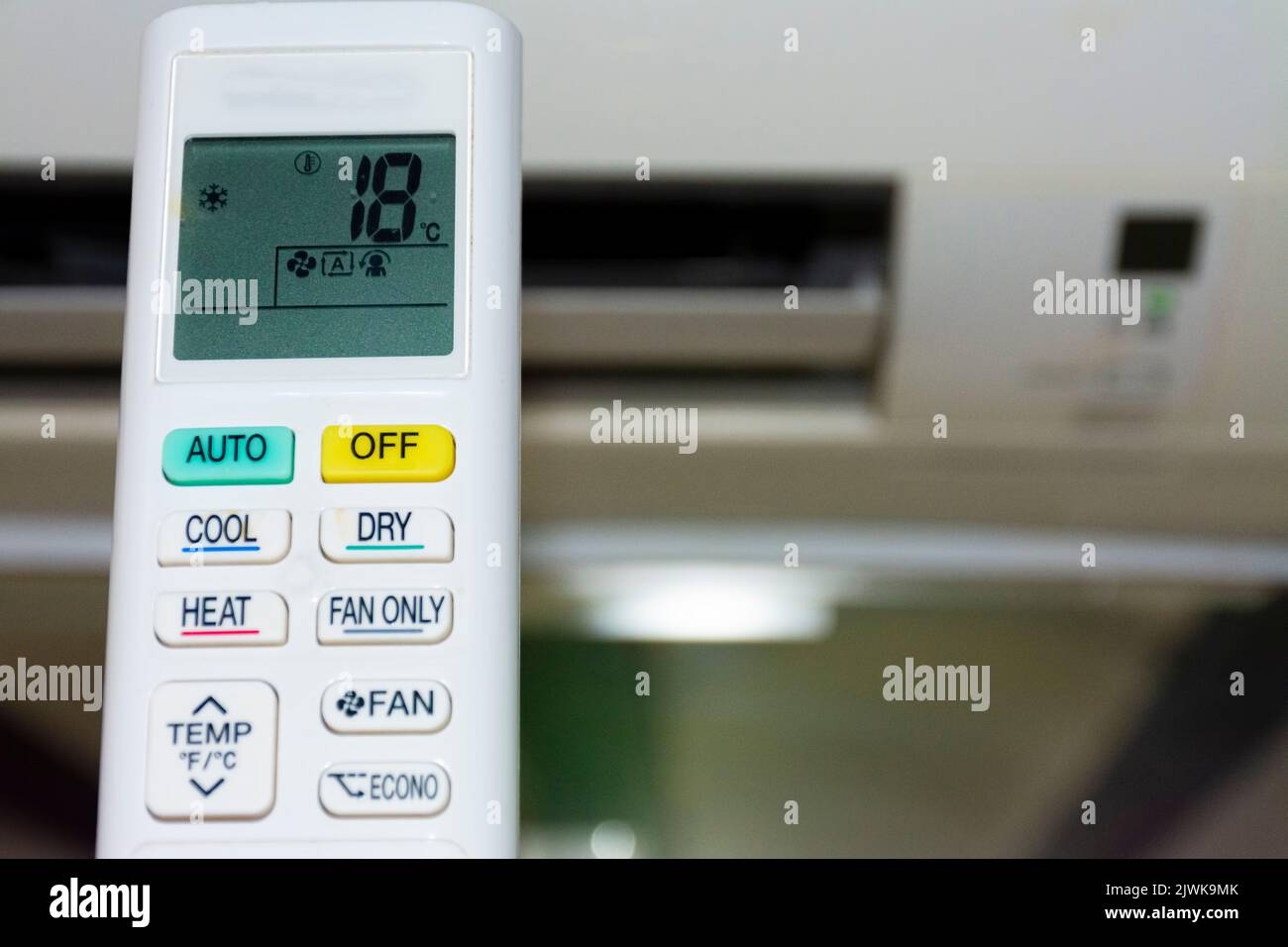 Controllo remoto dell'aria condizionata, contrassegno di bassa temperatura. Sfondo sfocato. Concetto di spreco di energia Foto Stock