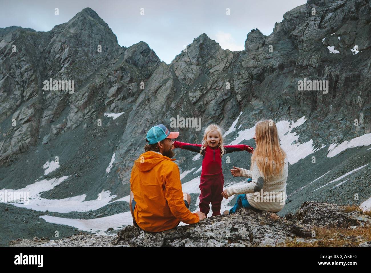 Bambino ragazza escursioni con i genitori in montagna famiglia viaggio vacanze estate campeggio avventura all'aperto attivo sano stile di vita padre e madre playin Foto Stock