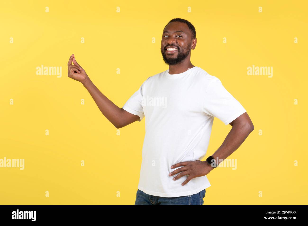 Allegro African American Guy cliccando dita in piedi su sfondo giallo Foto Stock