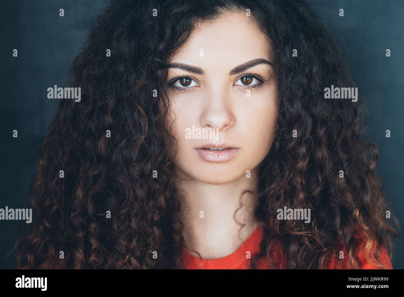 giovane donna capelli ricci fissa concentrazione dello sguardo Foto Stock