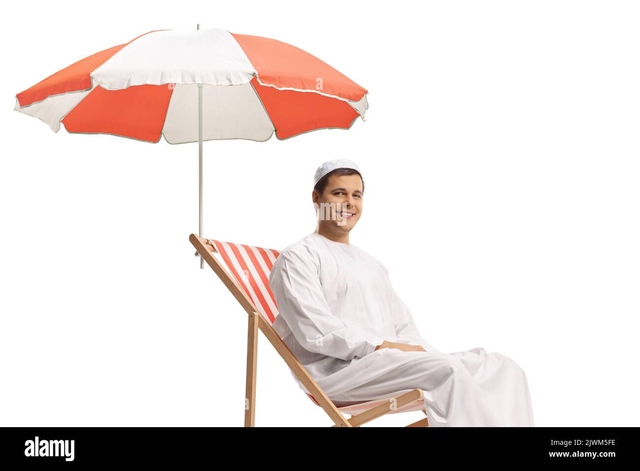 Uomo in abiti etnici seduto su una sedia da spiaggia sotto un ombrellone isolato su sfondo bianco Foto Stock