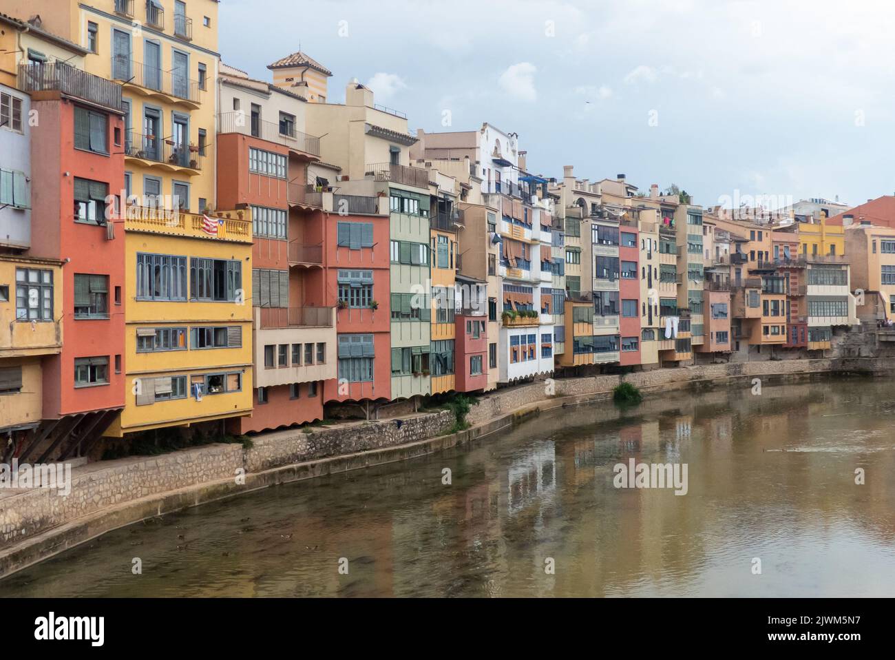 Girona e il fiume Onyar sotto cieli minacciosi Foto Stock