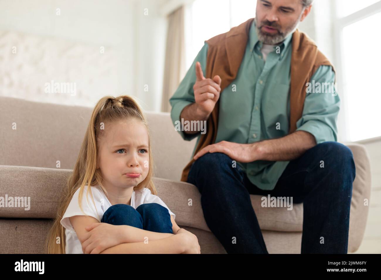 Piccola ragazza frustrato che sula mentre papà la scola a casa Foto Stock