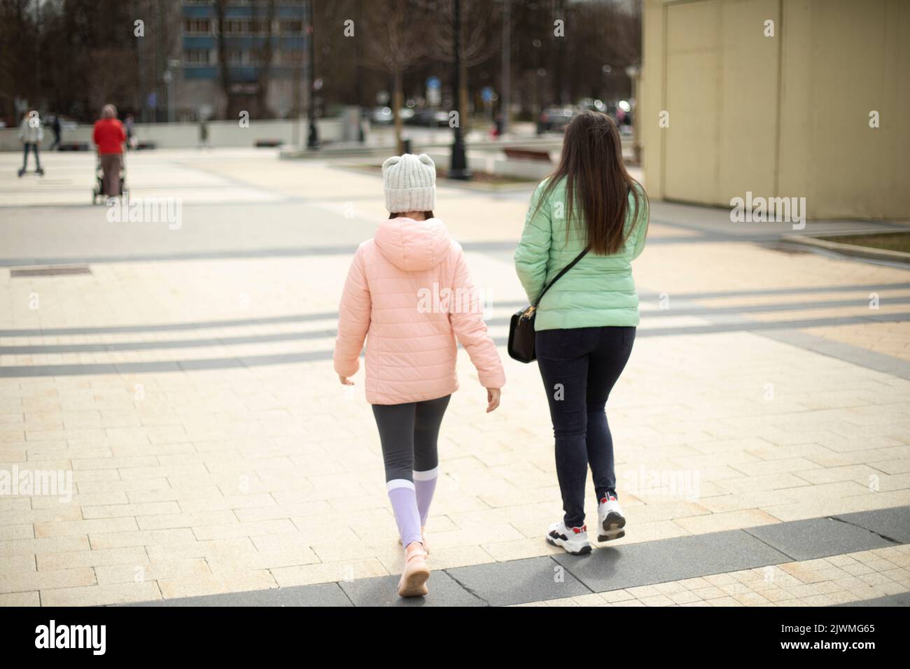Due ragazze camminano attraverso la piazza. Foto Stock