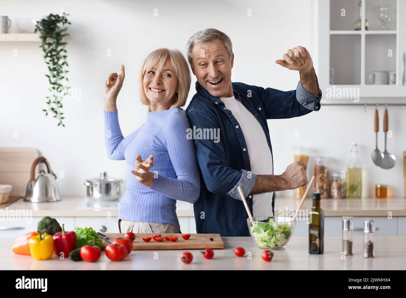 Marito e moglie senior divertenti mentre cucinano Foto Stock