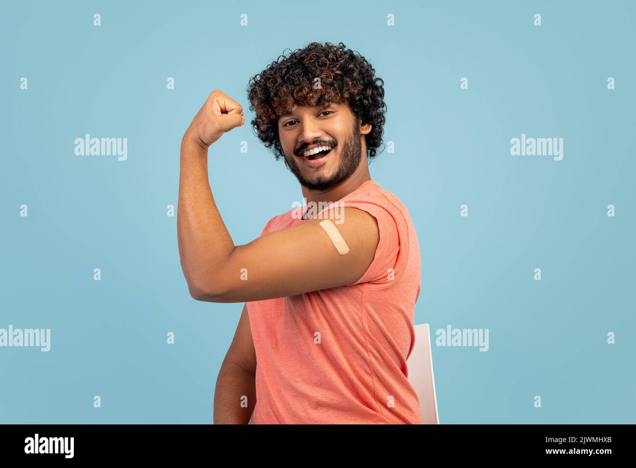 Bell'uomo indiano che mostra bicipiti con cerotto adesivo Foto Stock