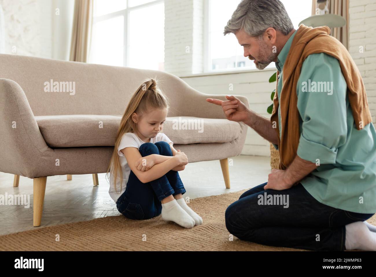 Strict papà scolding figlia minacciandola con il dito a casa Foto Stock