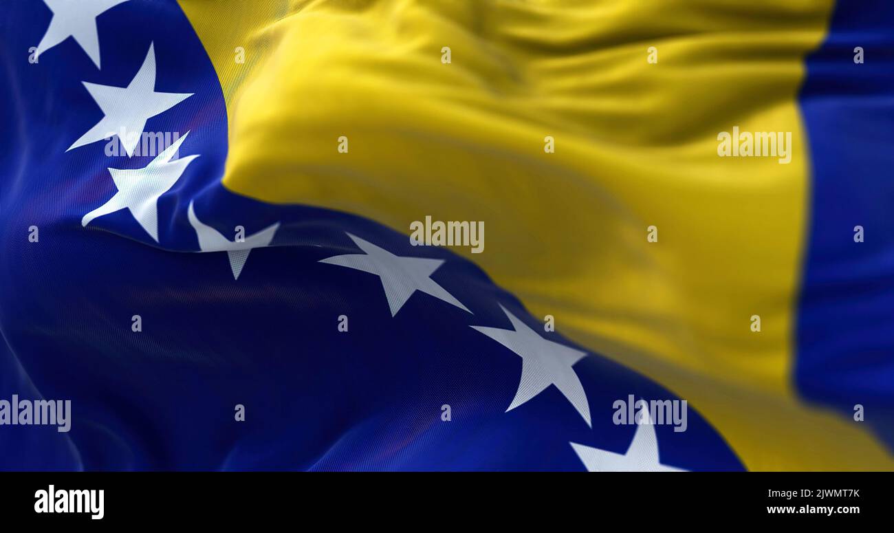 Vista ravvicinata della bandiera bosniaca che sventola nel vento. La Bosnia-Erzegovina è un paese che si trova al crocevia tra il sud e il sud-est dell'Europa. Fa Foto Stock