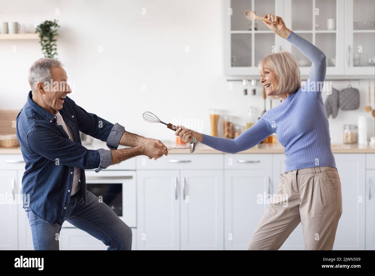 Coppia anziana che ama divertirsi insieme in cucina, divertendosi Foto Stock