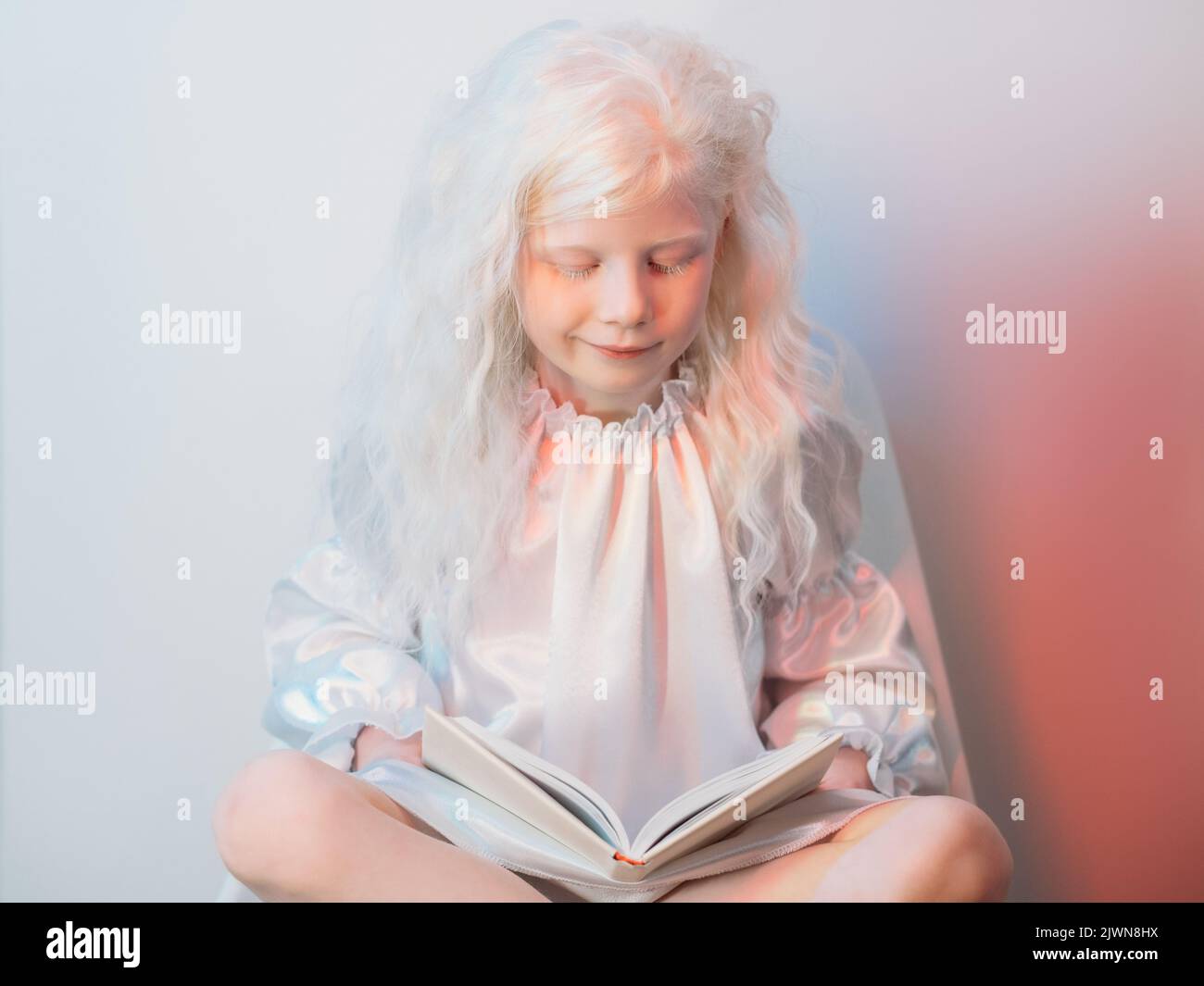 libro di lettura della ragazza bionda di storia di hobby del capretto di tempo Foto Stock
