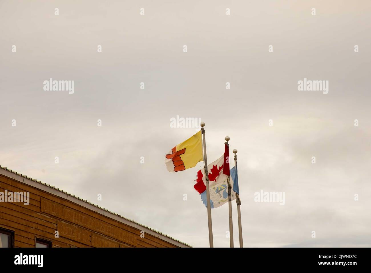 Bandiera del nuovo territorio Nunavut accanto alla bandiera canadese e alla bandiera del comune di Cambridge Bay a Cambridge Bay, Victoria Island, Nunavut, Canada. Foto Stock