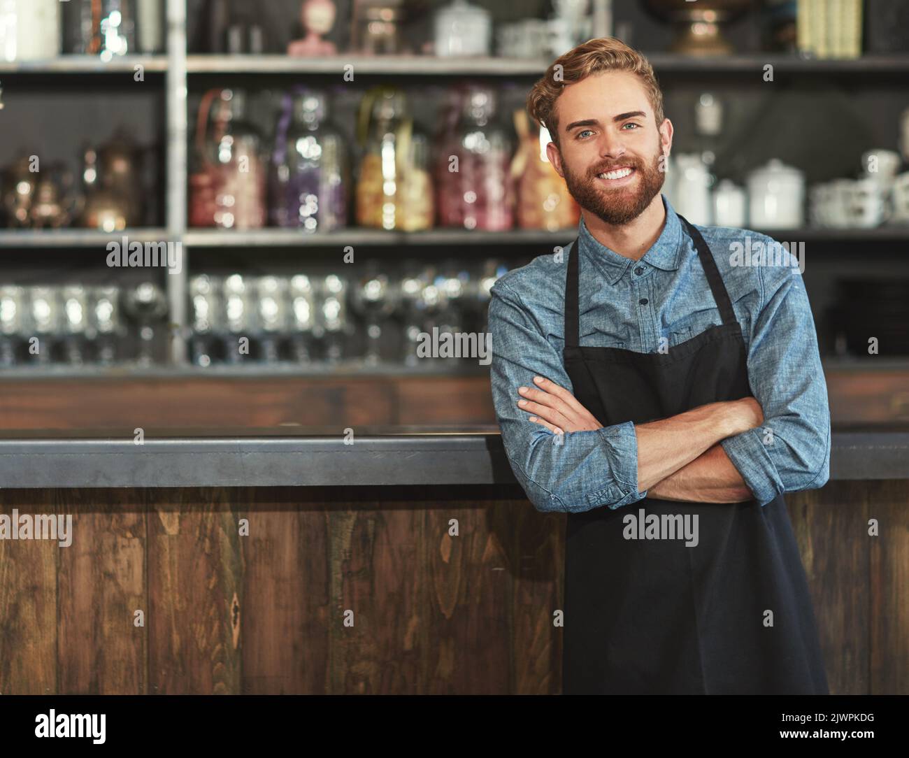 Sorrisi di successo nella caffetteria. Ritratto di un giovane barista che lavora in un bar. Foto Stock
