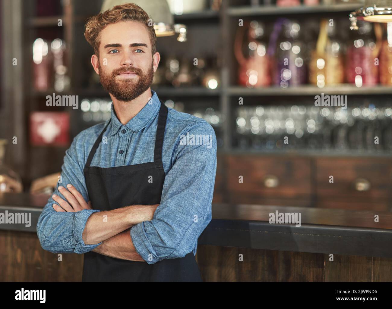 È bello gestire una caffetteria di successo, un giovane barista che lavora in un bar. Foto Stock