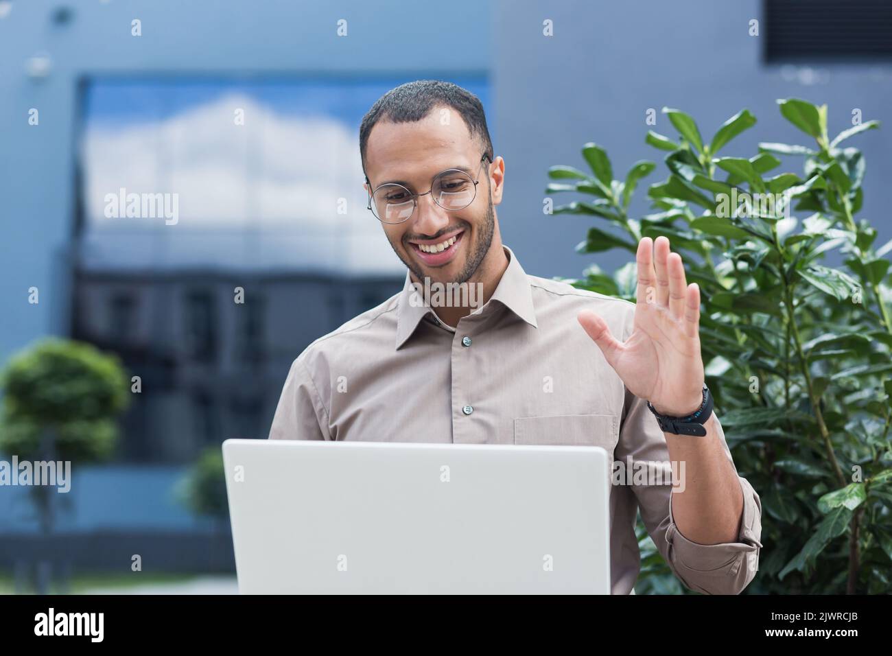 Giovane studente afro-americano che usa il laptop per videochiamare, uomo d'affari fuori dall'ufficio, sorridente e felice interlocutore di saluto, conferenza on-line riunione remota. Foto Stock