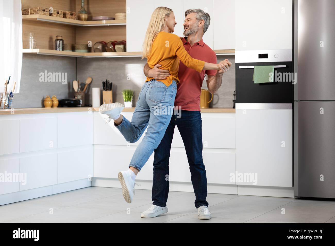 Amare la coppia di mezza età divertirsi in cucina, ballare Foto Stock