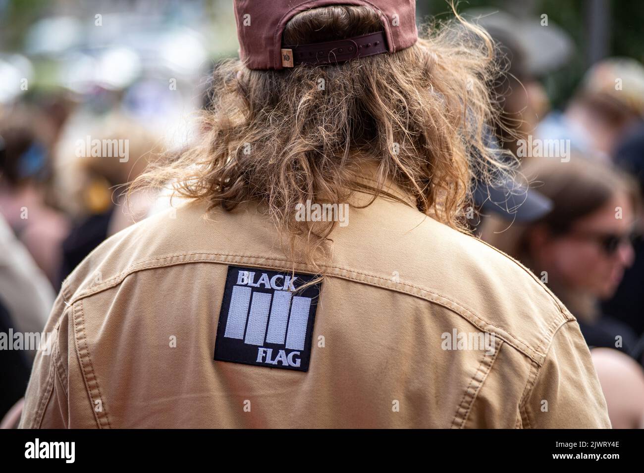 Uomo con un cerotto Black Flag sul retro della giacca Foto Stock