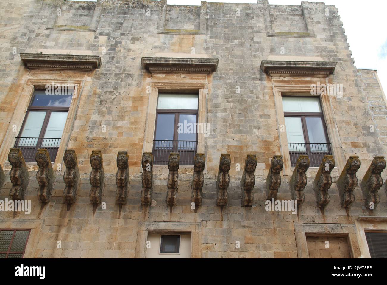 Casarano, Italia. Vista esterna di Palazzo D'Aquino. Lunga fila di cornici figurate per sostenere un balcone che non è mai stato costruito. Foto Stock
