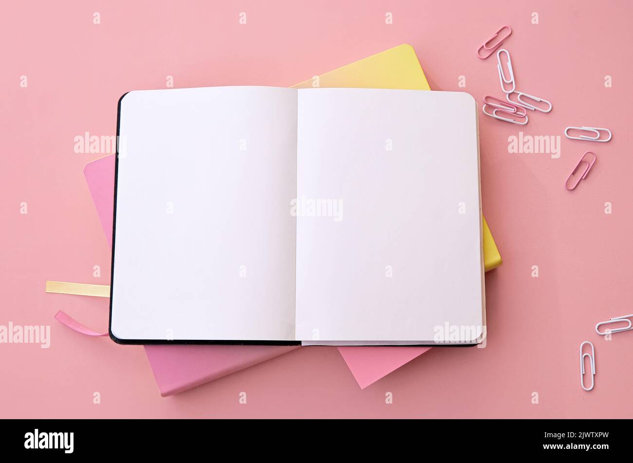 Torna a scuola forniture quaderno aperto su sfondo rosa, piatto, spazio copia. Foto Stock