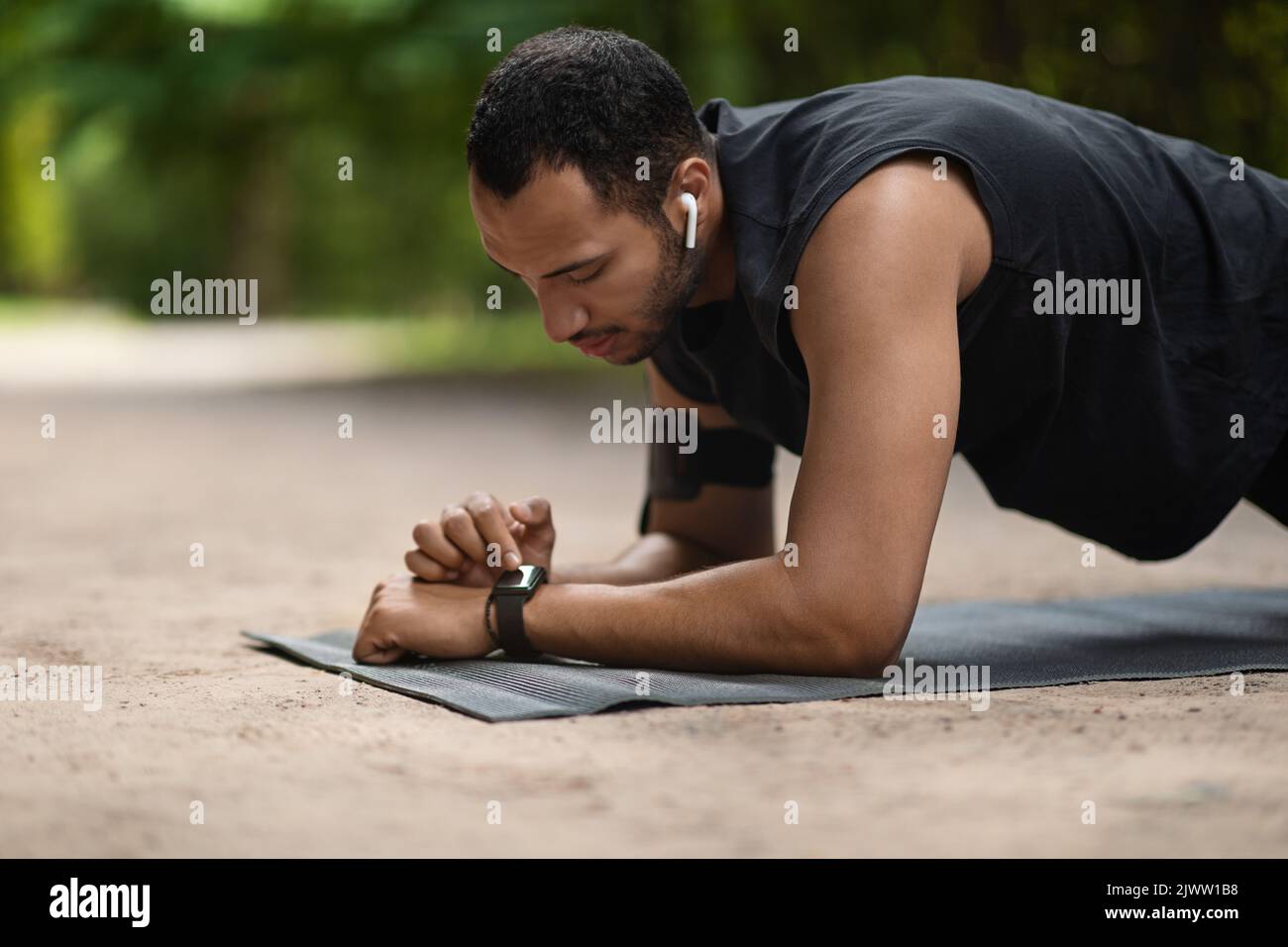 Bel giovane uomo sportivo nero ha impostato il suo fitness tracker Foto Stock