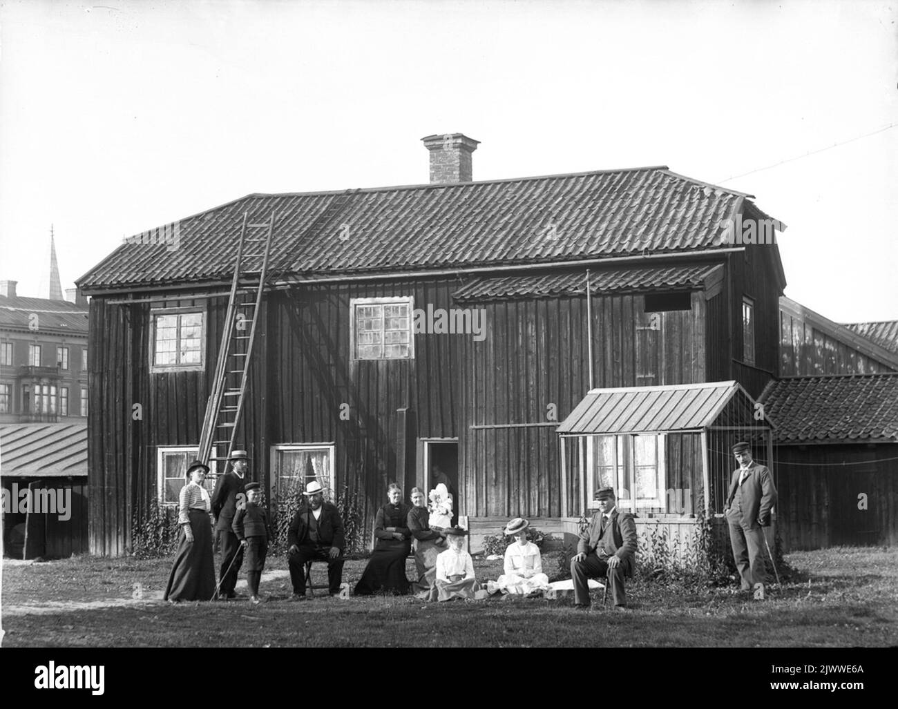 Gruppo di persone di fronte ad un edificio in legno. Forse a Gävle. Grupp AV människor framför en träbyggnad. Eventuellt i Gävle. Foto Stock