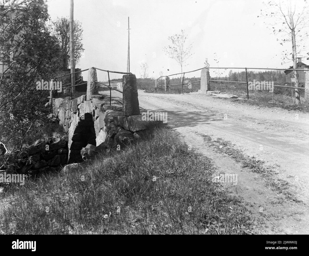 Ponte sulla strada vecchia. Il bellissimo ponte vecchio a Åsmundshyttan, da sud-est con 'Mattas' Lilla Gården sulla destra. La ringhiera del ponte di ferro è ora installato intorno alla cabina a Wibyhyttttan. La foto è stata scattata intorno al 1926. L'immagine è inclusa nella Torsåkers Photo-Historical Company. Pagina immagine 1 Gamla landsvägsbron. Den vackra gamla bron i Åsmundshyttan, från sydost med 'Mattsas' lilla gården till Höger. Broräcket AV järn är nu uppsatt runt hyttpan i Wibyhyttttan. Bilden är lagen omkring 1926. Bilden finns med i Torsåkers Fotohistoriska Sällskap. Bildsida 1 Foto Stock