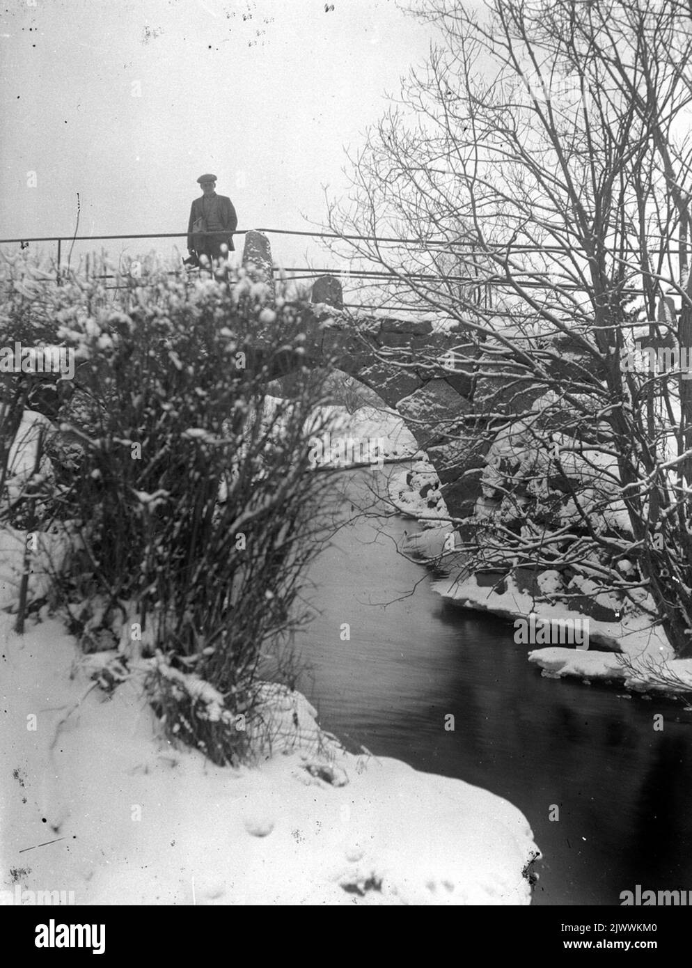 Vecchio ponte stradale sul fiume a Åsmundshyttan demolito al rilevamento stradale dopo il Ågärvningen nel 1928. Sul ponte si trova il collega del fotografo 'Anders-Ols' Enok Eriksson. Gamla landsvägsbron över ån i Åsmundshyttan riven vid vägomläggningen efter ågrävningen 1928. på bron står fotografens kollega 'Anders-Ols' Enok Eriksson. Foto Stock