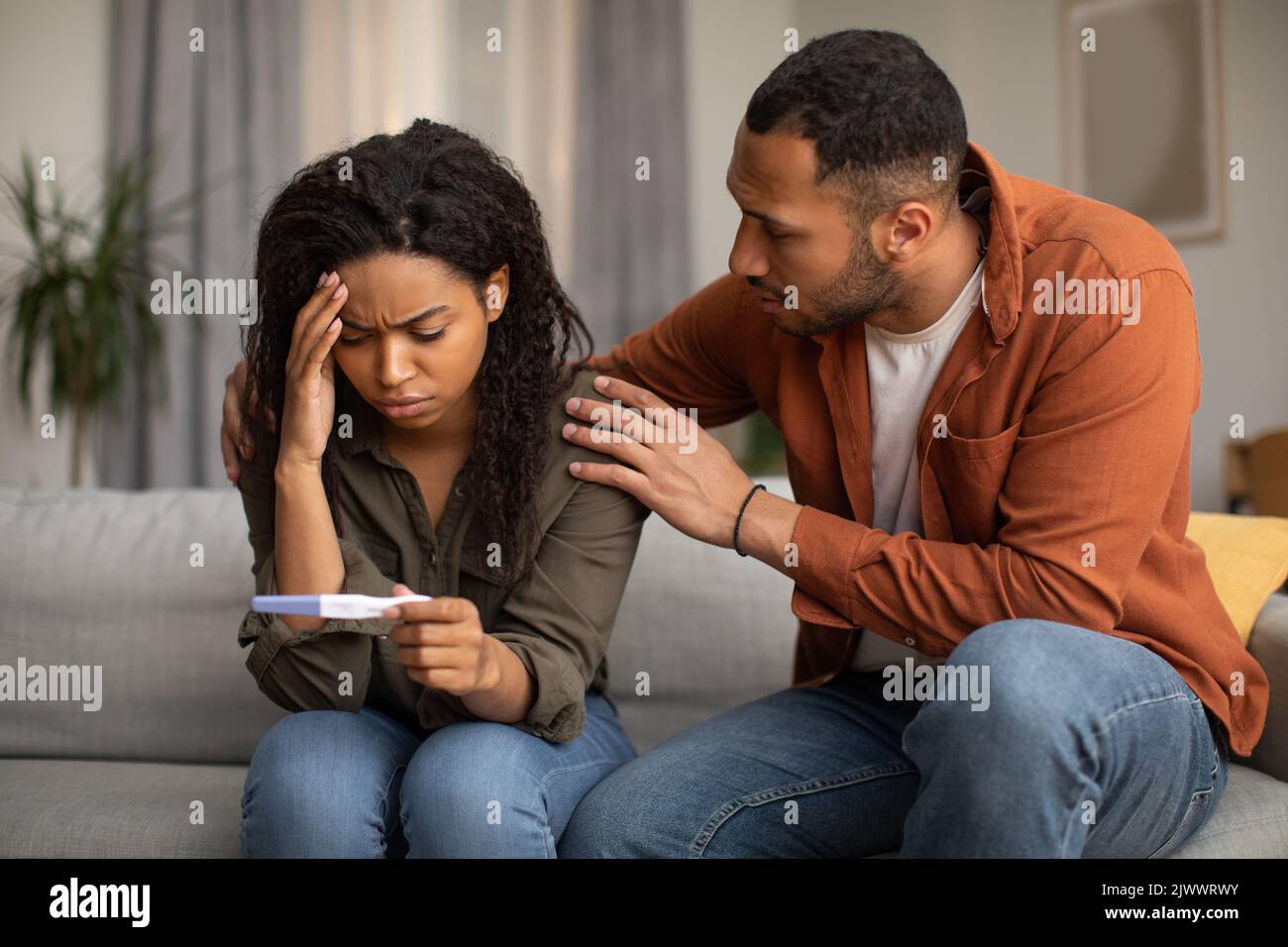 Unhappy African American Couple Holding Test di gravidanza negativa a casa Foto Stock