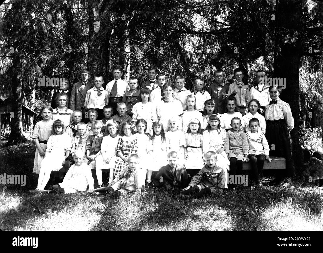 Insegnante con una collezione di studenti della scuola nella foresta. Lärarinna med en samling skolelever i skogen. Foto Stock