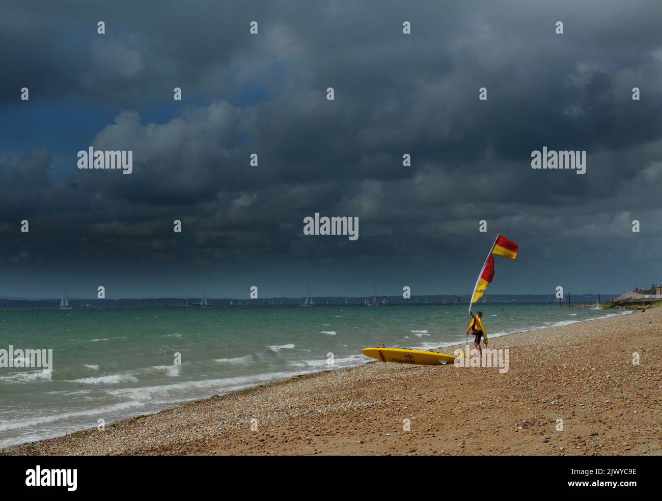 UN BAGNINO SULLA SPIAGGIA A SOUTHSEA MENTRE LE NUVOLE DI PIOGGIA SI MUOVONO DENTRO. A DIFFERENZA DI ALCUNI GIORNI FA, QUANDO LA SPIAGGIA ERA RICCA DI GENTE CHE SI GODEVA L'ONDA DI CALORE. PIC MIKE WALKER, MIKE WALKER IMMAGINI, 2013 Foto Stock